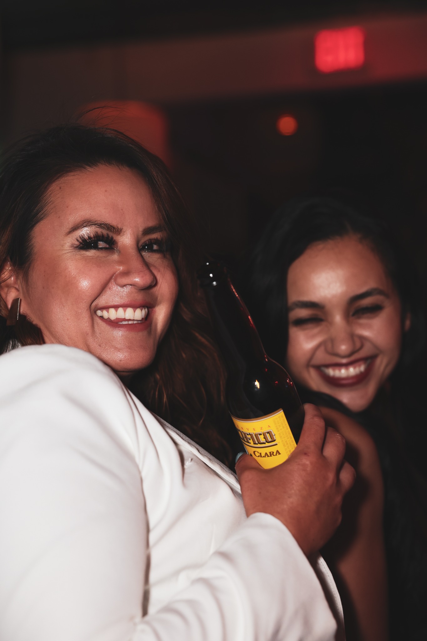 Two guests smiling together during an evening celebration, photographed by ShutterQueue