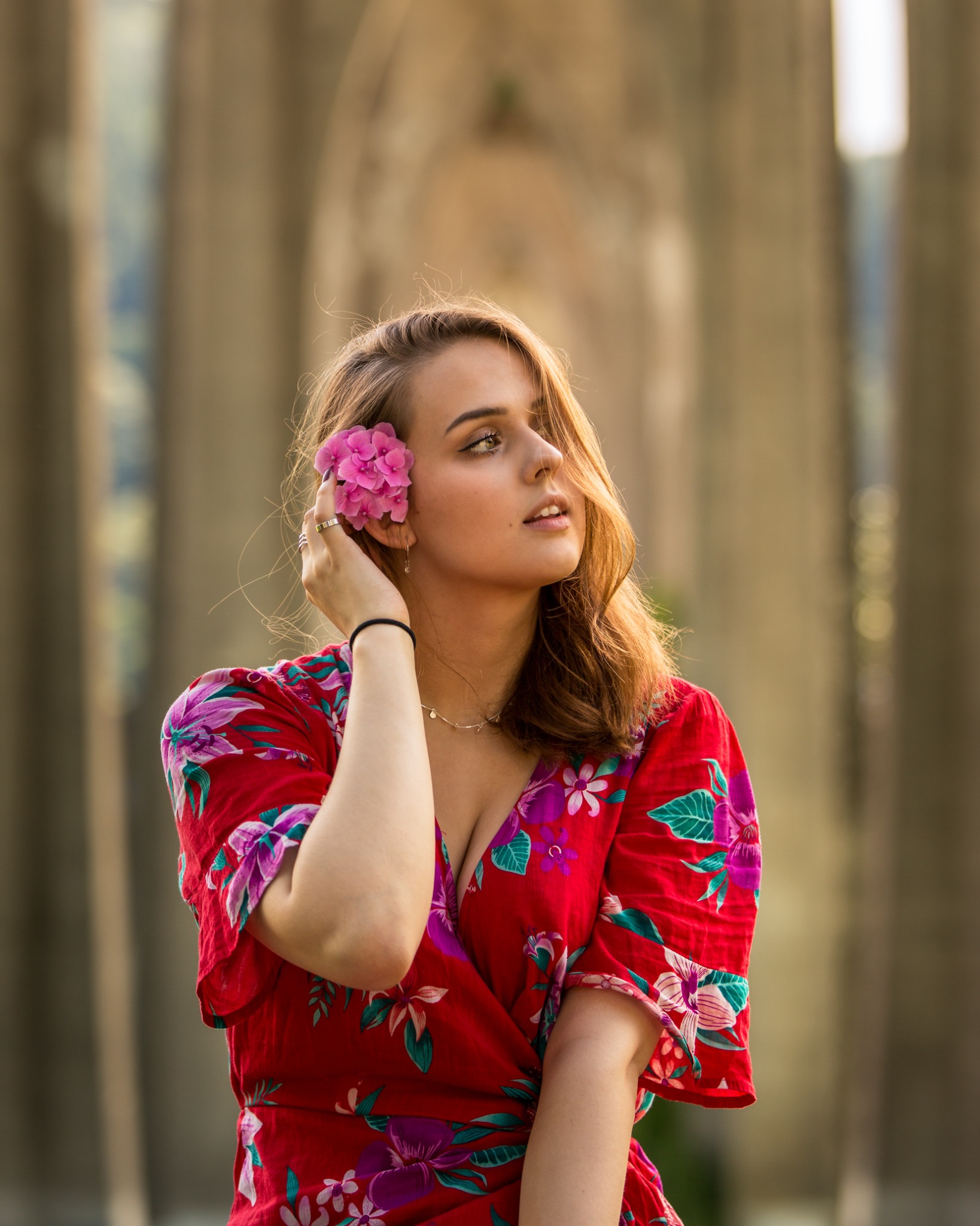 Portrait in a floral red dress among tall columns