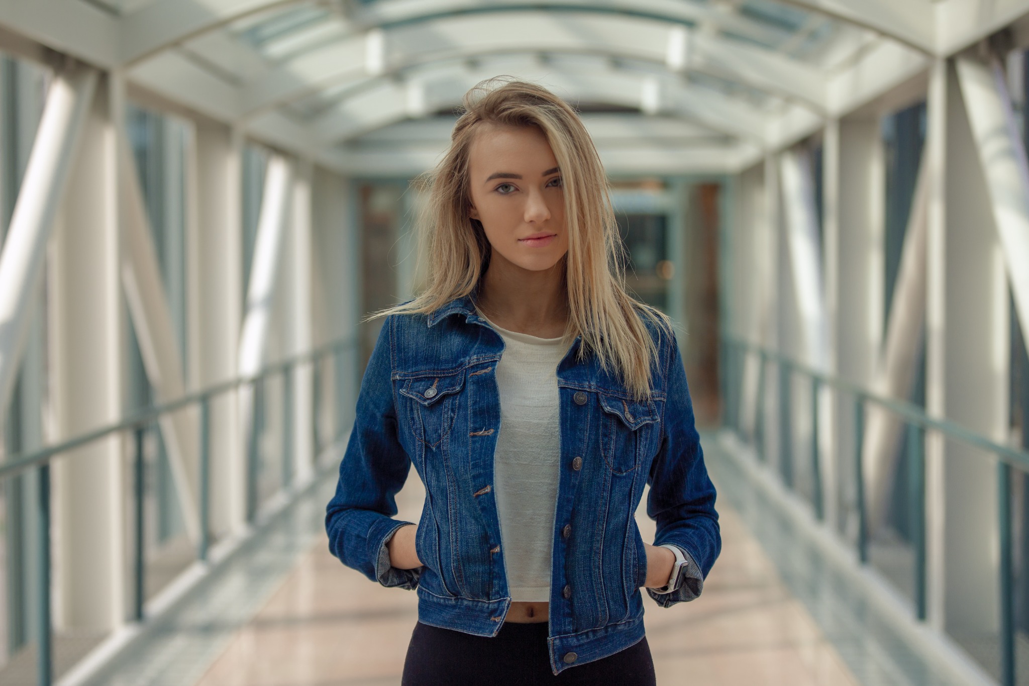 Portrait in a denim jacket on a glass walkway
