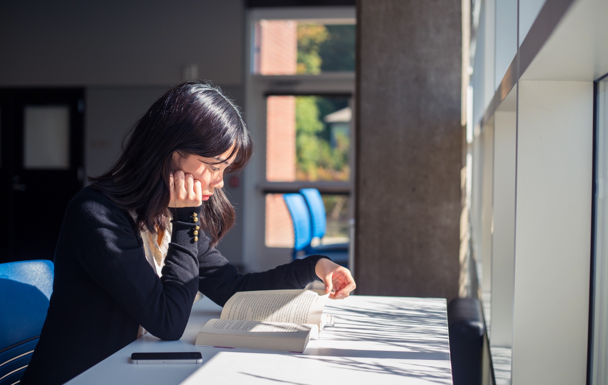 Portrait of a woman working beside a sunlit window